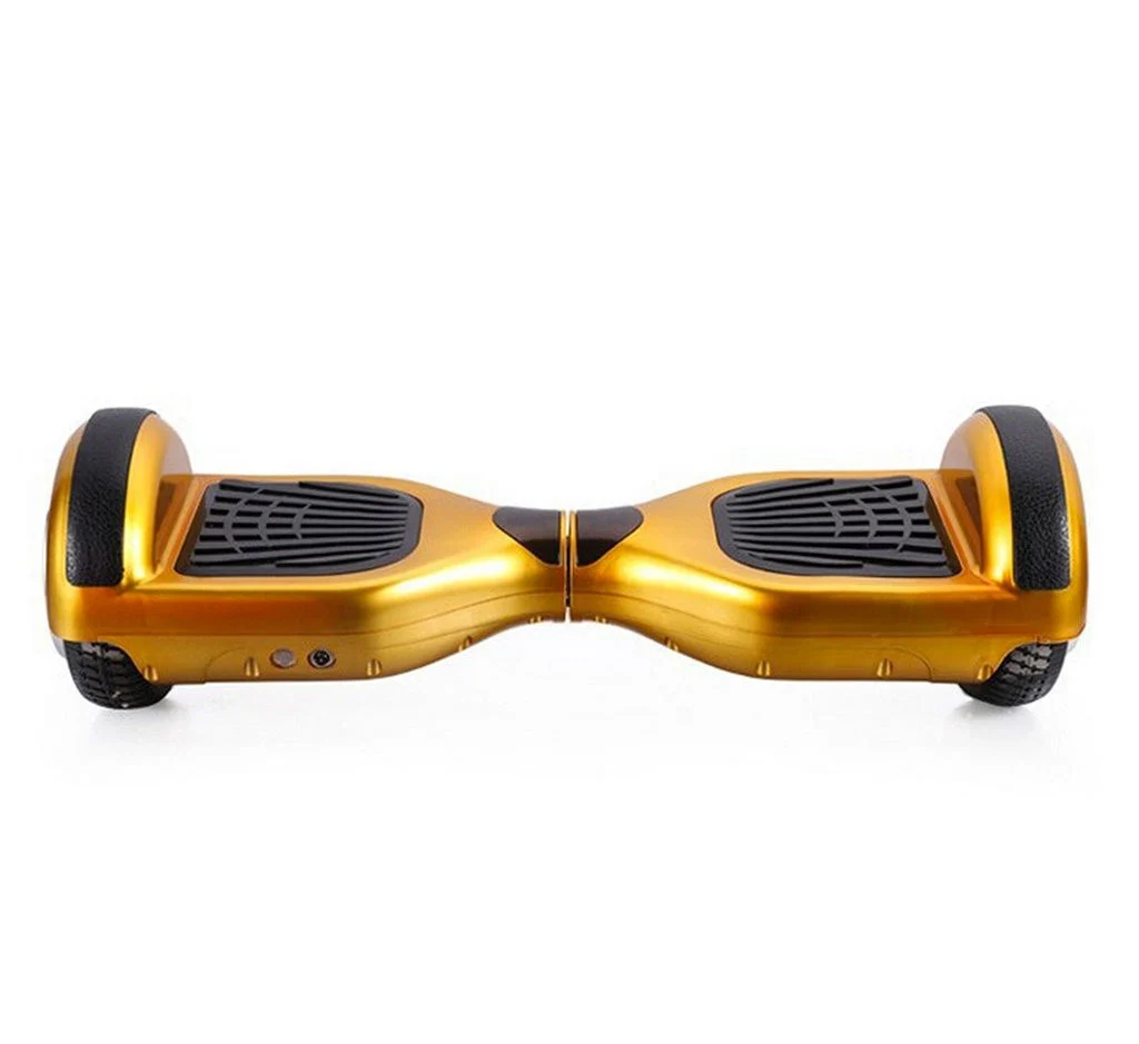 Glossy gold-colored self-balancing hoverboard viewed from the front with black foot pads on white background, warm mood